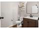 This cozy powder room features a charming vanity, decorative shelving, and warm wood-look flooring at 7531 W Rock Springs Dr, Peoria, AZ 85383