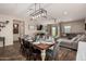 This dining room features a modern chandelier, wood floors, and an open layout to the living room at 7531 W Rock Springs Dr, Peoria, AZ 85383