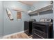 Laundry room with black front load washer and dryer, and rustic decorations at 7531 W Rock Springs Dr, Peoria, AZ 85383