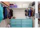 Closet with clothes hanging on rod, storage shelf on top, and light-blue chest of drawers below at 7531 W Rock Springs Dr, Peoria, AZ 85383