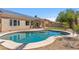 Backyard pool with updated concrete decking, desert landscaping, solar panels, and a covered patio at 7919 E Posada Ave, Mesa, AZ 85212