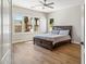 Bedroom with hardwood floors, a wood bed frame, and three windows overlooking the yard at 7919 E Posada Ave, Mesa, AZ 85212