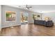 Bright living room featuring hardwood floors, a ceiling fan, and sliding glass doors to the outdoor space at 7919 E Posada Ave, Mesa, AZ 85212