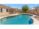 Backyard pool with desert landscaping, grass, string lights, and a covered patio at 7919 E Posada Ave, Mesa, AZ 85212