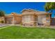 Exterior view of a well landscaped home featuring manicured lawns and desert rock at 9420 E Plata Ave, Mesa, AZ 85212