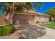 View of a two car garage with desert landscaping and lush green yard at 9420 E Plata Ave, Mesa, AZ 85212