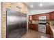 This kitchen features stainless appliances, a stone backsplash, granite counters, and dark wood cabinets at 9420 E Plata Ave, Mesa, AZ 85212