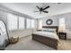 Bright bedroom featuring large windows, a ceiling fan, and a comfortable king-sized bed at 9742 W Los Gatos Dr, Peoria, AZ 85383