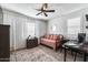 Cozy bedroom with a dark wood dresser, neutral rug, and lots of natural light at 9742 W Los Gatos Dr, Peoria, AZ 85383