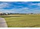 Large grassy lawn area within the community, with residential homes visible in the distance at 9742 W Los Gatos Dr, Peoria, AZ 85383