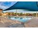 Community pool with lounge chairs, shaded area, and a stainless steel table and chairs in foreground at 9742 W Los Gatos Dr, Peoria, AZ 85383