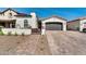 Charming single-story home exterior featuring a cobblestone driveway, brown garage door, and desert landscaping at 9742 W Los Gatos Dr, Peoria, AZ 85383