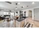 Open concept kitchen featuring a center island with black countertop and adjacent dining and living area at 9742 W Los Gatos Dr, Peoria, AZ 85383