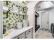 Well-organized laundry room with bright wallpaper, custom shelves, and white cabinets, and modern appliances at 9742 W Los Gatos Dr, Peoria, AZ 85383