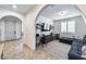 Bright living room featuring an arched entryway and stylish black shelving with workspace at 9742 W Los Gatos Dr, Peoria, AZ 85383