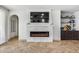 Living room featuring a tiled fireplace with a mounted TV, wet bar, and an archway to another room at 9742 W Los Gatos Dr, Peoria, AZ 85383