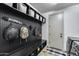 Functional mud room with a bench, storage baskets, and hanging hooks, adjacent to a laundry area at 9742 W Los Gatos Dr, Peoria, AZ 85383