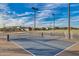 Outdoor pickleball court with blue surface and lighting, set against a backdrop of homes and a blue sky at 9742 W Los Gatos Dr, Peoria, AZ 85383