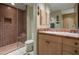 Bathroom features a step-in glass shower and vanity with tan tile countertops at 9904 E Lookout Mountain Dr, Scottsdale, AZ 85262