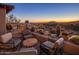 Outdoor patio seating with stone wall and sunset mountain views at 9904 E Lookout Mountain Dr, Scottsdale, AZ 85262