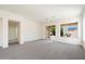 Bright living room featuring a ceiling fan, glass sliding doors, and carpet at 10588 E Tierra Buena Ln, Scottsdale, AZ 85255