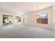 Spacious living room featuring grey carpet, a ceiling fan, and a sliding glass door at 10588 E Tierra Buena Ln, Scottsdale, AZ 85255