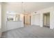 Open concept living room with grey carpet, a chandelier, and lots of natural light at 10588 E Tierra Buena Ln, Scottsdale, AZ 85255