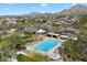 Aerial view of a community pool and pool house, complete with lounge chairs, desert landscaping and mountain views at 10588 E Tierra Buena Ln, Scottsdale, AZ 85255