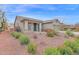 Lovely home featuring desert landscaping, complemented by vibrant red flowers and mature vegetation at 11305 W Monte Vista Rd, Avondale, AZ 85392