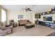 Comfortable living room features neutral tones, tile flooring, ceiling fan, and media center with built-in shelving at 11305 W Monte Vista Rd, Avondale, AZ 85392