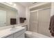 Bathroom with a white vanity with a sink, a toilet, and a shower with glass doors at 12535 W Brandywine Dr, Sun City West, AZ 85375
