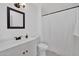 Bathroom featuring white sink, vanity, and toilet; framed mirror; and tiled shower at 13808 N Silverbell Dr, Sun City, AZ 85351