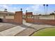 Attractive brick entry to Elgin Court featuring decorative rock landscaping and wrought iron gate at 13808 N Silverbell Dr, Sun City, AZ 85351