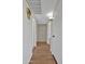 Hallway featuring hardwood floors, storage cabinets, and neutral paint at 13808 N Silverbell Dr, Sun City, AZ 85351