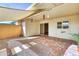 Covered patio featuring brick floors, shade sail, decorative plants, and access to home at 13808 N Silverbell Dr, Sun City, AZ 85351