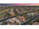 Expansive aerial view showcases well-planned community with various homes, streets, and desert landscaping against a colorful sky at 15145 W Catalina Dr, Goodyear, AZ 85395