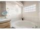 Soaking tub with glass block window lets in plenty of light in this spacious primary bath at 15145 W Catalina Dr, Goodyear, AZ 85395