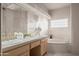 Bright bathroom features dual sinks, soaking tub with glass block window, and a neutral color palette at 15145 W Catalina Dr, Goodyear, AZ 85395