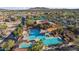 Aerial view of a community pool with shaded seating areas, surrounded by palm trees at 15145 W Catalina Dr, Goodyear, AZ 85395