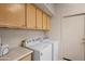 Bright laundry room features washer and dryer, ample cabinet space, and laminate countertops at 15145 W Catalina Dr, Goodyear, AZ 85395