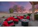 Inviting outdoor patio with a cozy fire pit and comfortable red cushioned seating area, perfect for relaxation under the sky at 15145 W Catalina Dr, Goodyear, AZ 85395