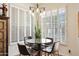 Cozy dining area bathed in light, featuring a modern chandelier and views of the lush outdoors at 15240 N Clubgate Dr # 162, Scottsdale, AZ 85254