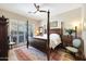 Bedroom showcasing a four-poster bed, wood floors, shutters, and elegant decor for a cozy retreat at 15240 N Clubgate Dr # 162, Scottsdale, AZ 85254