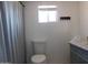 This bathroom features a toilet, shower with curtain, window, and countertop with storage at 1531 W Naranja Ave, Mesa, AZ 85202