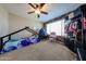 A cozy ' bedroom with playful decor, a wooden accent wall, natural light, and ample closet space at 17531 W Hedgehog Pl, Surprise, AZ 85387