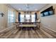 Bright dining area featuring a large wooden table, upholstered chairs, a bench, and modern light fixtures at 17531 W Hedgehog Pl, Surprise, AZ 85387