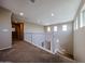 Upstairs hallway with neutral walls, white railing, carpet flooring, and views of other rooms in the home at 17531 W Hedgehog Pl, Surprise, AZ 85387