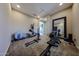 Home gym featuring a rowing machine, elliptical machine, large mirror and ample workout space at 17531 W Hedgehog Pl, Surprise, AZ 85387