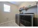 Laundry room with modern washer and dryer and tiled flooring at 17531 W Hedgehog Pl, Surprise, AZ 85387