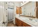 Bathroom with dual vanity sinks and a framed mirror, along with an enclosed shower at 17727 N 95Th Pl, Scottsdale, AZ 85255